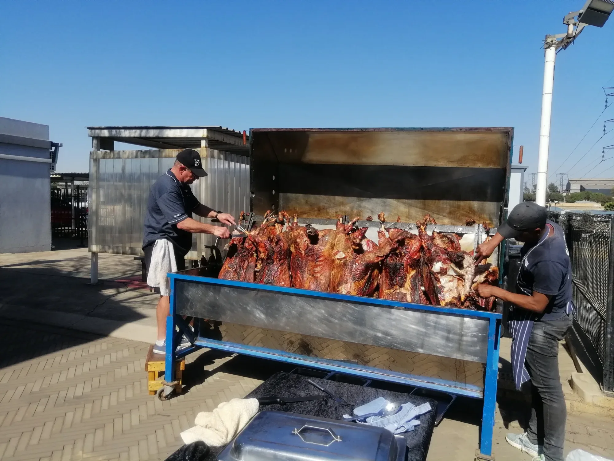 Chefs preparing spit braai meats outdoors