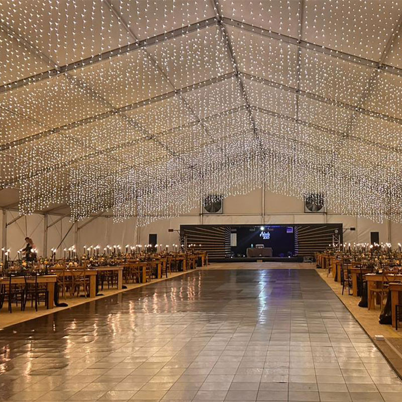 Large illuminated indoor event space with a dance floor and tables