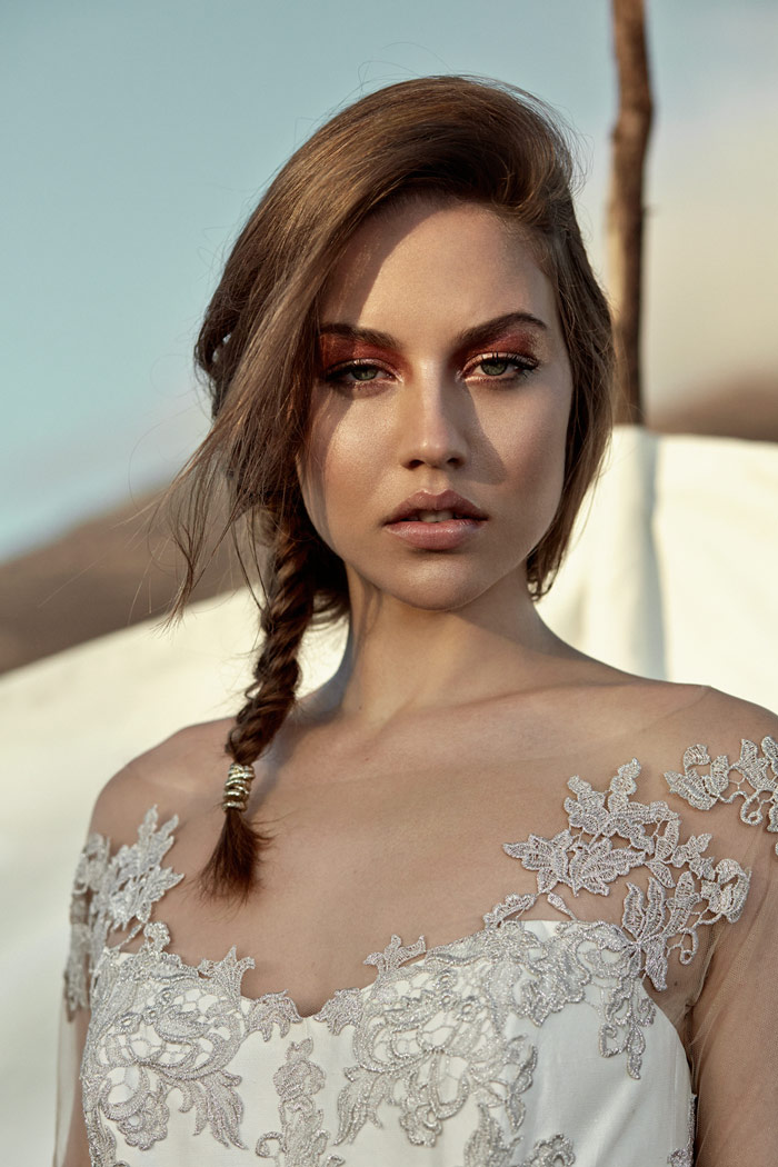 Close-up of a bride with a detailed lace gown and braided hairstyle
