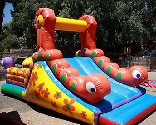 Brightly colored caterpillar-themed jumping castle with slide.