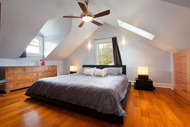 Bright attic room with wooden floors and elegant decor.