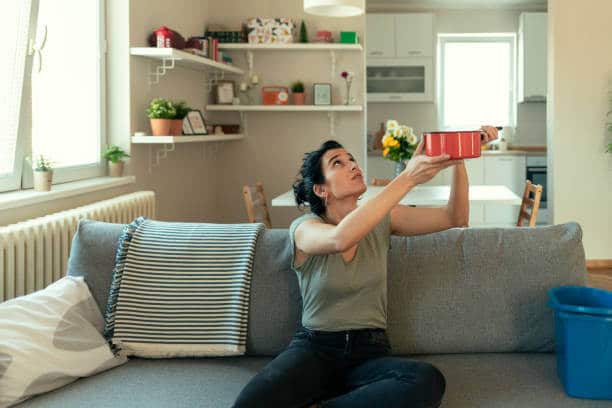 Person holding a makeup kit while sitting on a couch