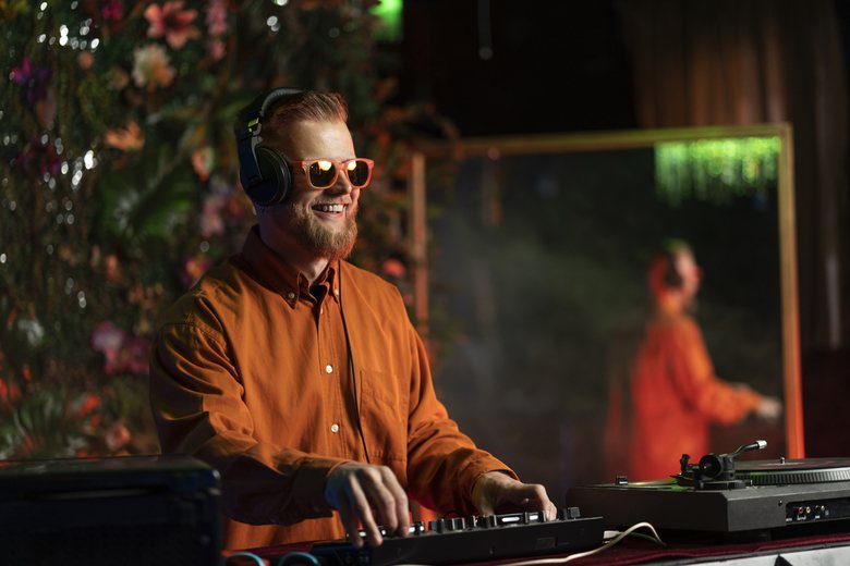 DJ playing at an event with floral backdrop